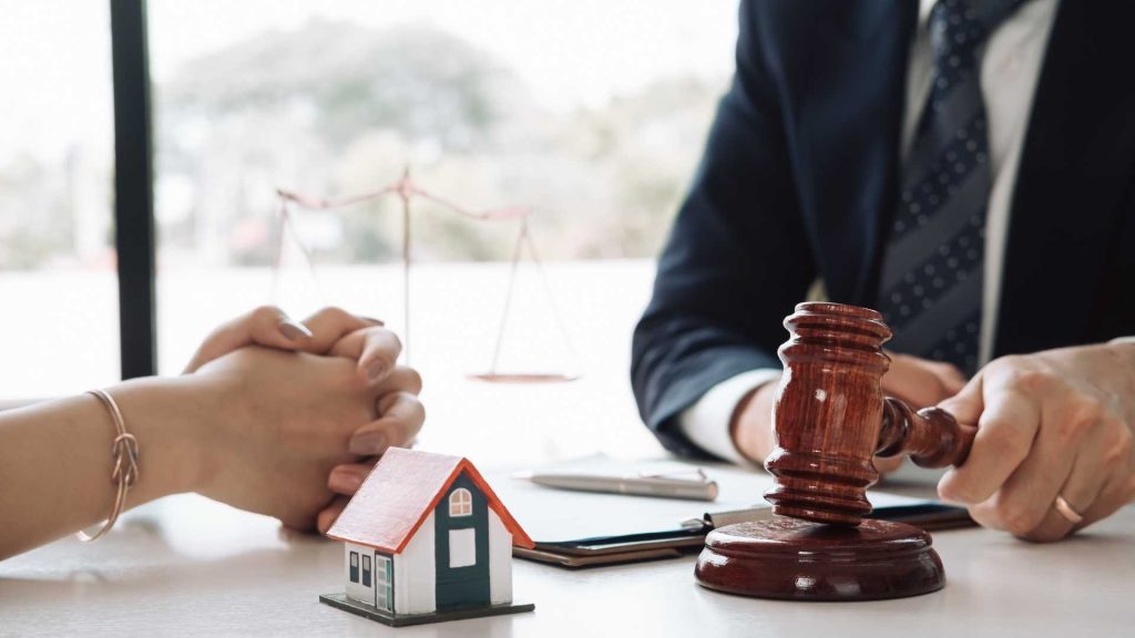 a contract a gavel and a home figurine on a desk