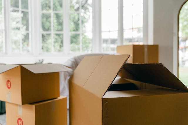 a bunch of brown moving boxes in front of a large window