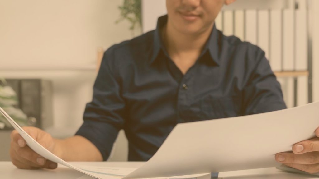 a person looking over a couple of documents